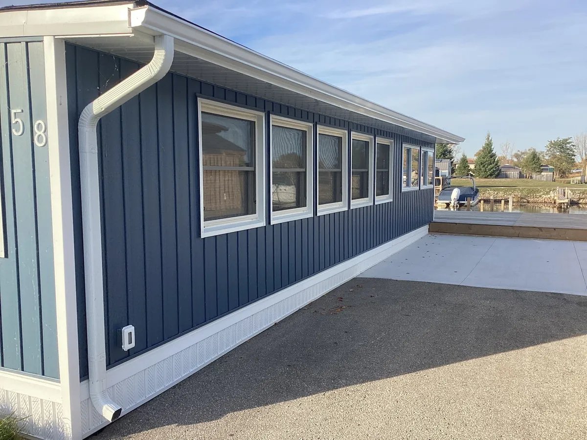 Waterfront cottage with new blue board and batten siding