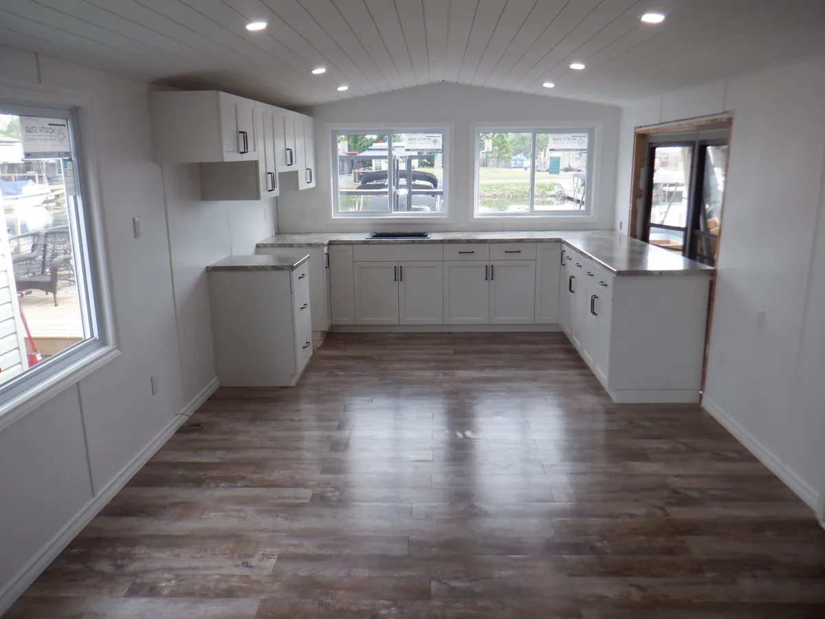 Finished kitchen renovation with white cabinetry and vinyl plank flooring