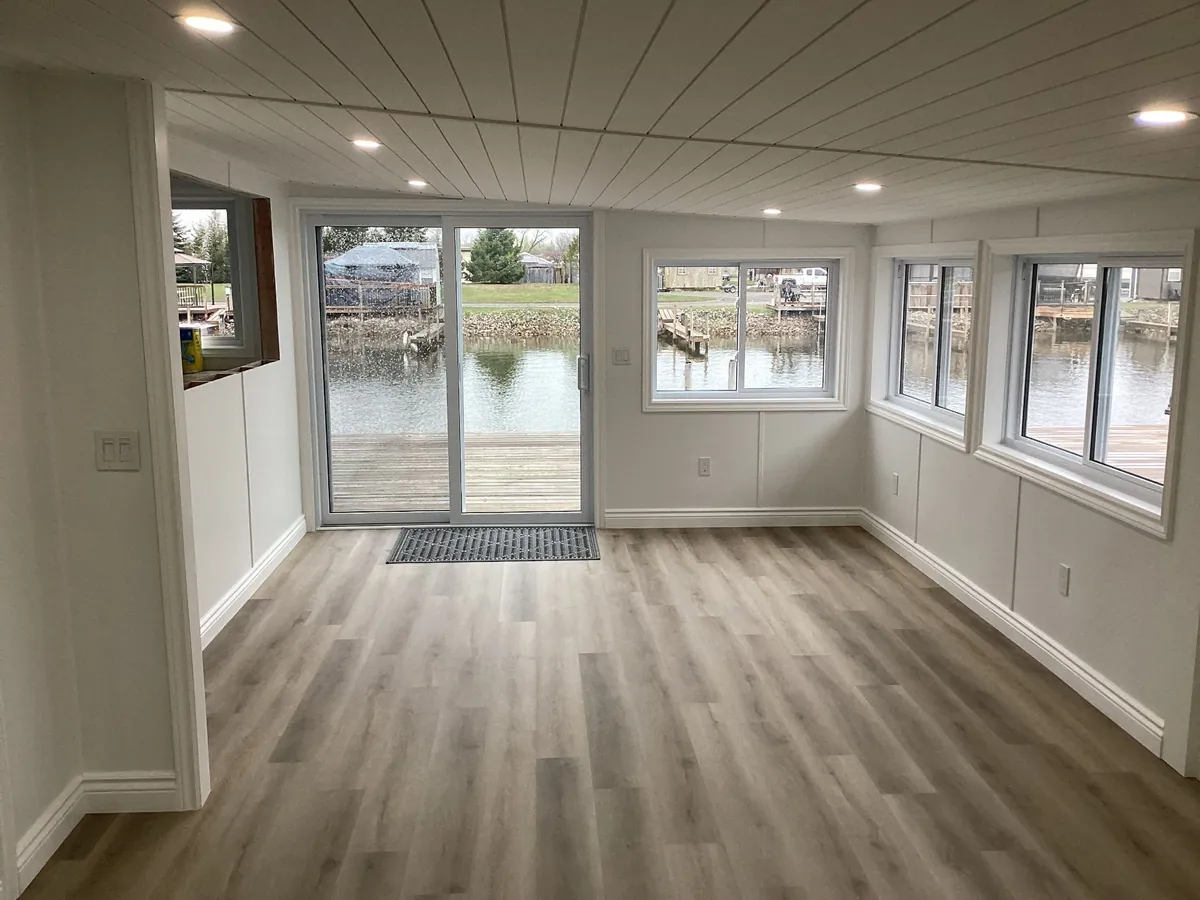 Waterfront sunroom addition with sliding patio doors