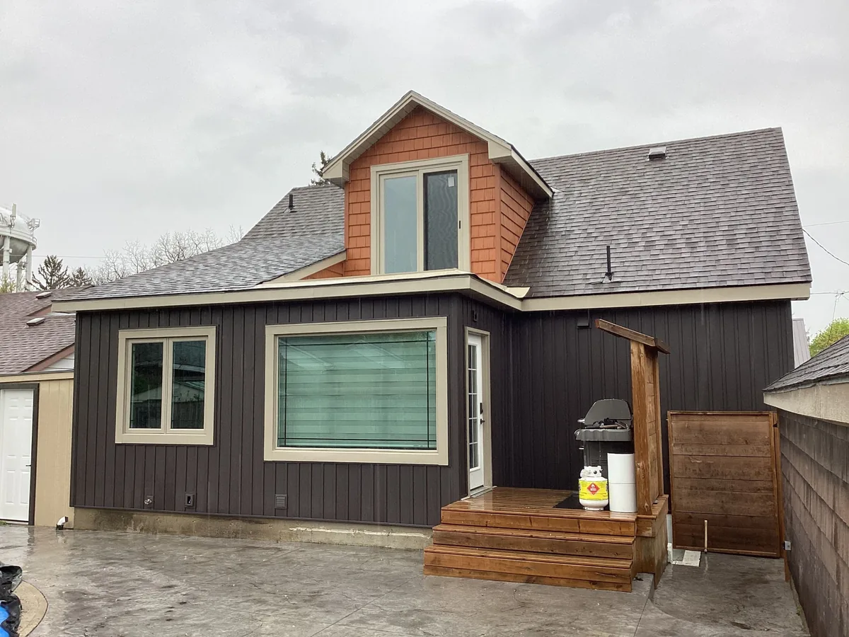 Dark board and batten siding with cedar shake gable accent