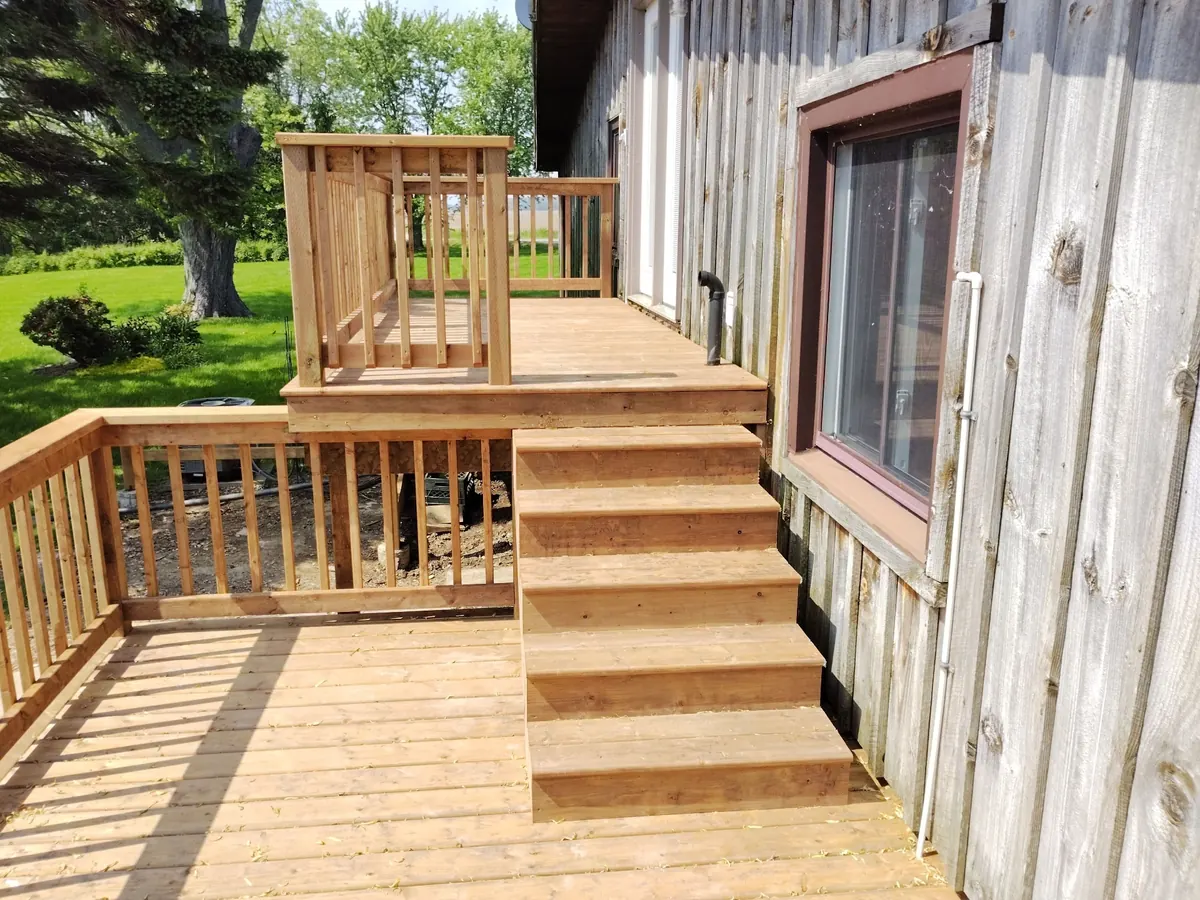Mid-build cedar deck with new stairs and upper landing framed in
