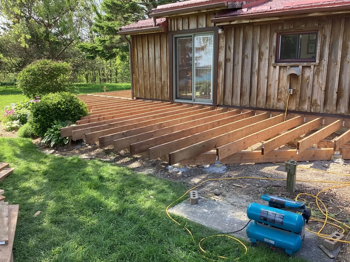 Pressure-treated deck joist framing along a cottage wall