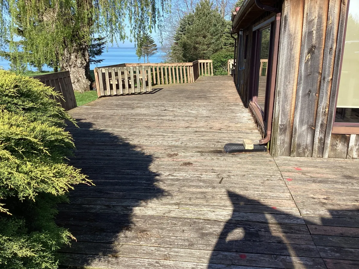 Original deck with grey weathered boards and failing railings