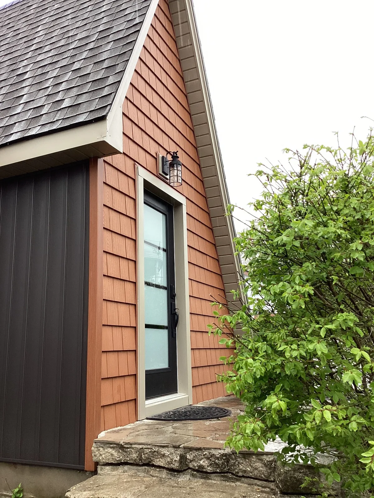 Cedar shake siding entry detail with board and batten and black door