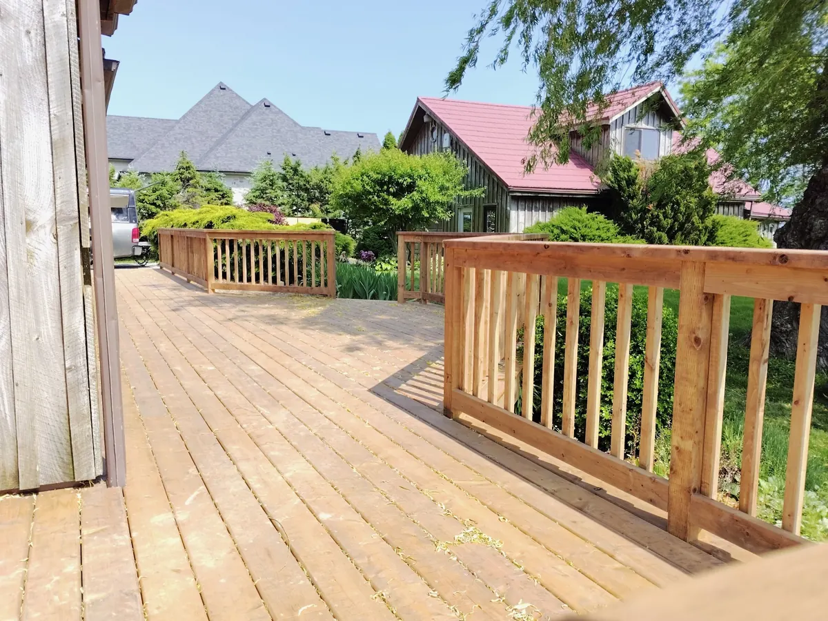 Finished cedar walkway with new guardrails running along the side of the home
